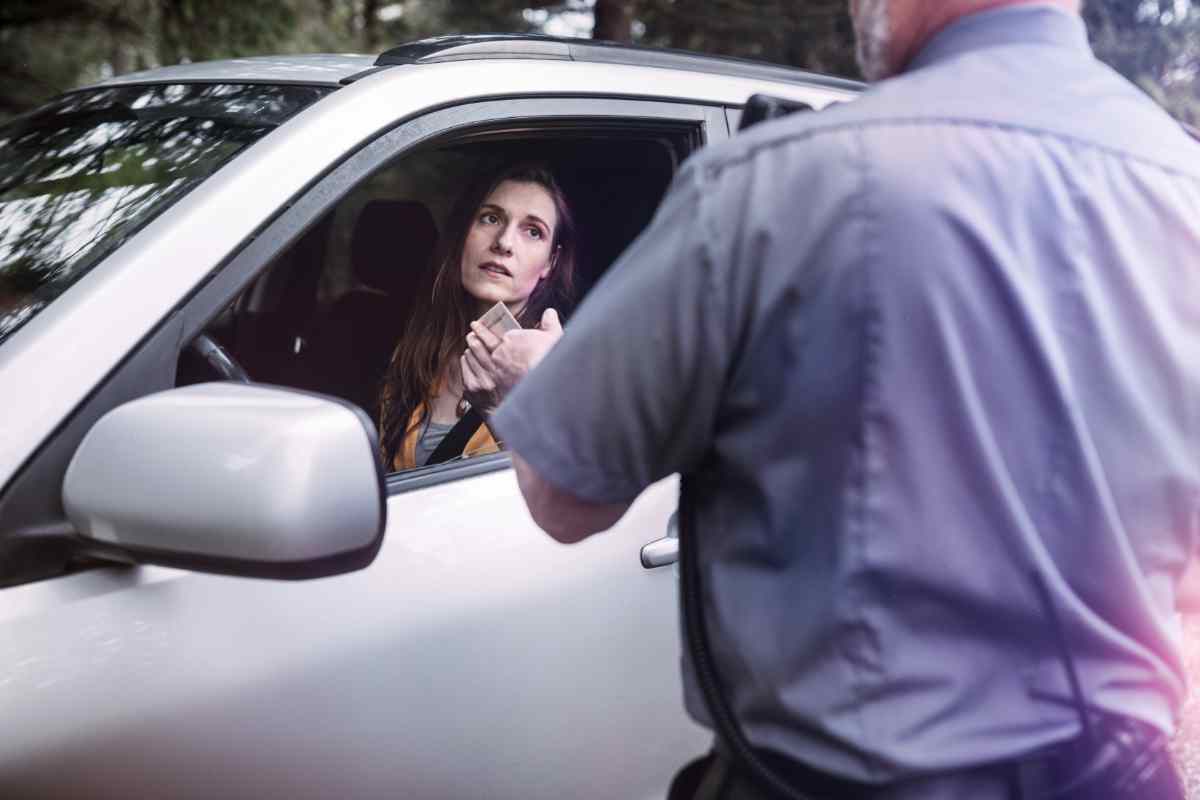 Donna mostra documenti a un poliziotto